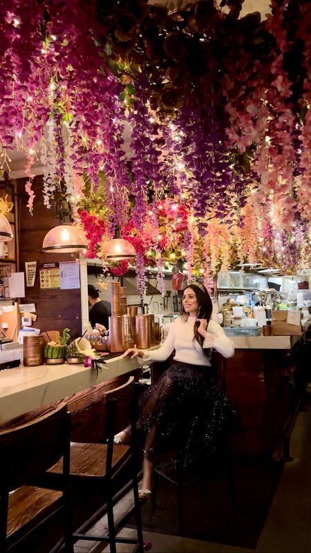 Roopsi Bansal in a Chicwish outfit at a NYC restaurant known for its hanging flower installation