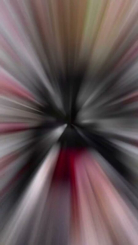 An abstract zoom-blur transition frame from a holiday CapCut tutorial reel, in warm pink and black tones