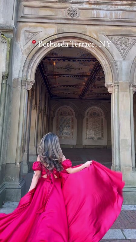 Roopsi Bansal in a red off-shoulder ballgown twirling through the tiled arcade at Bethesda Terrace in Central Park