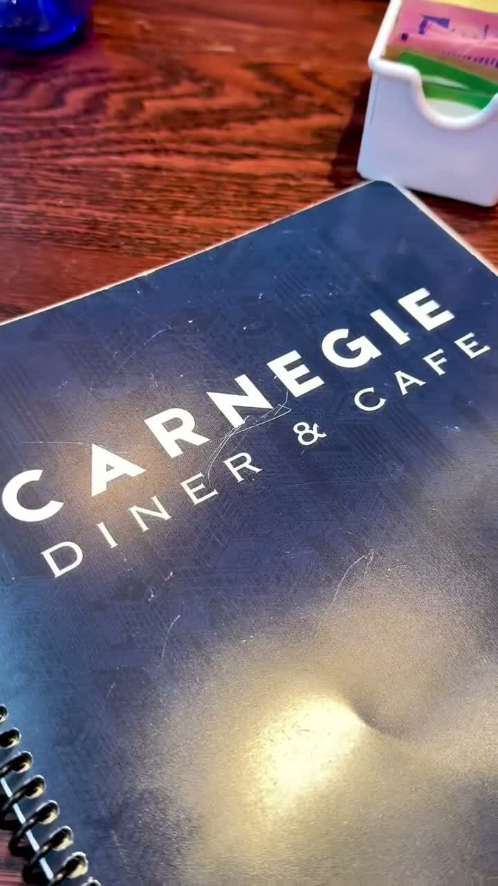 The blue Carnegie Diner & Cafe menu on a wooden table