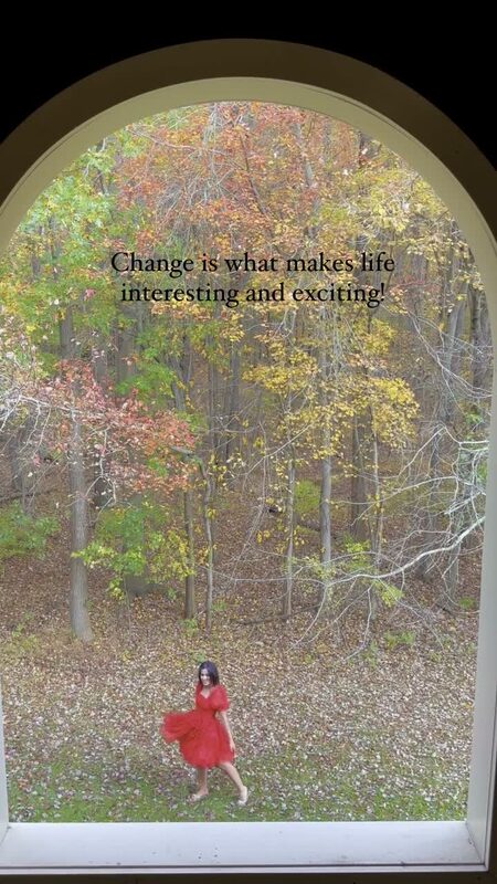 Roopsi Bansal in a red puff-sleeve dress from Shein framed through an arched window overlooking a leaf-covered backyard