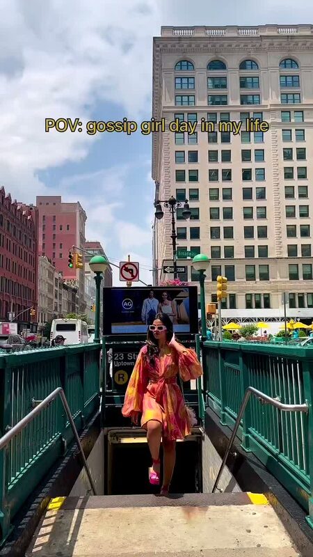 Roopsi Bansal in an orange and pink paisley chiffon dress emerging from a NYC subway station, captioned POV: gossip girl day in my life