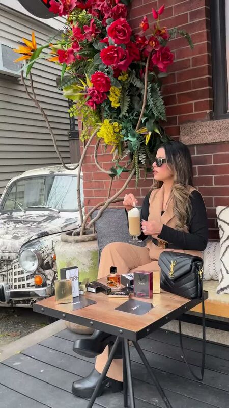 Roopsi Bansal with coffee and YSL Beauty perfume, wearing a jumpsuit