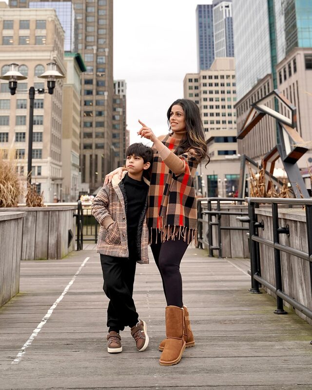 Roopsi Bansal in a knit poncho from Chicwish with fur-lined winter boots from Dream Pairs