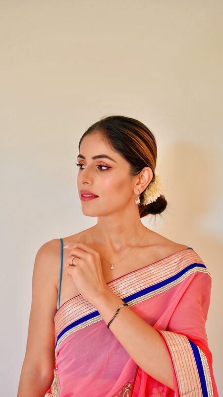 Roopsi Bansal in a pink and gold saree wearing a diamond necklace, earrings, and bracelet from CaratLane Global