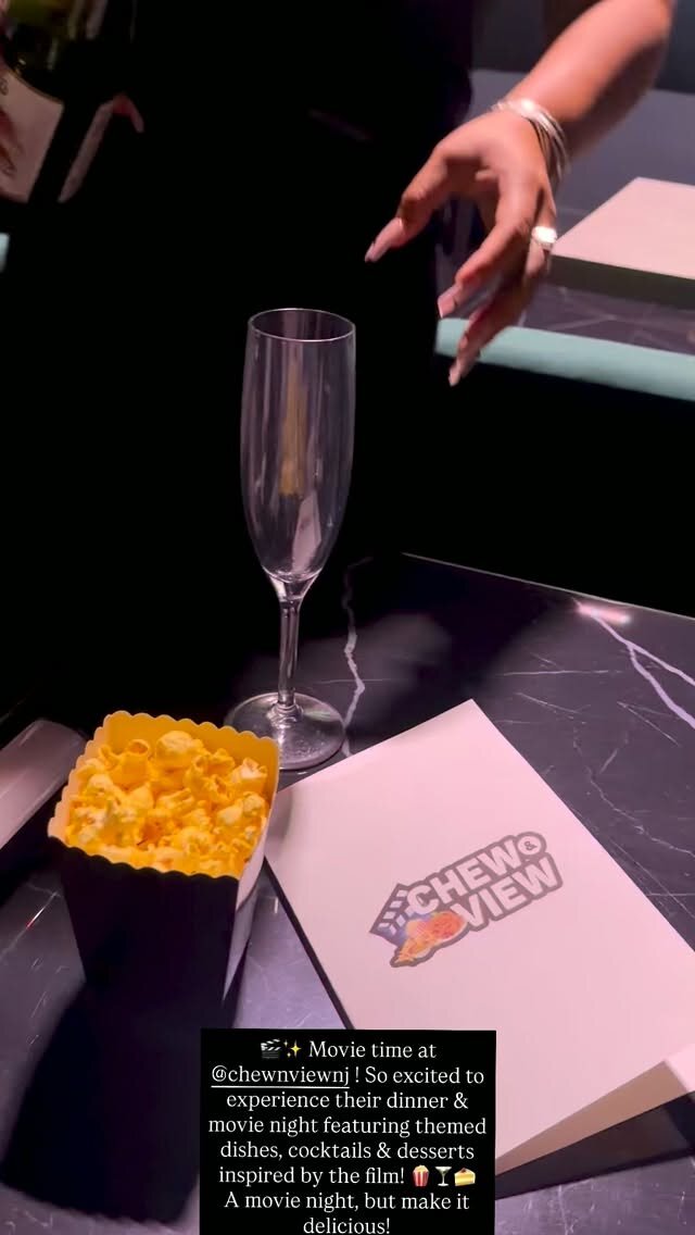 Popcorn and a champagne glass on the table at Chew & View NJ before a themed dinner-and-movie night