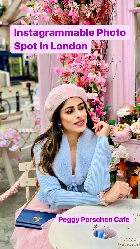 Roopsi Bansal in a pink pearl-embellished cap and a blue faux-fur trimmed top, seated at a table in front of the flower-covered Peggy Porschen Cafe