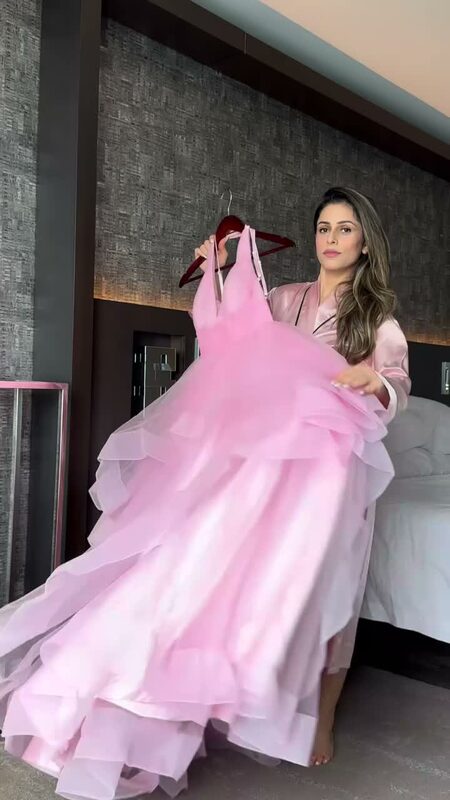 Roopsi Bansal in a pink dress from Laveliya at Empty Sky Memorial with the city skyline behind her