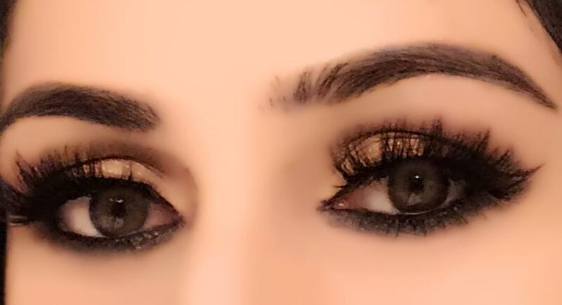 A close-up birthday smokey eye makeup look with soft golden shadow and deep smudged liner
