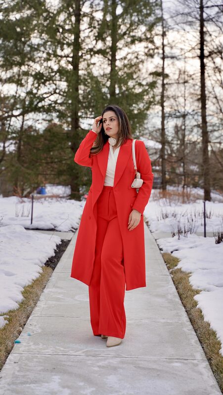Roopsi Bansal in a red tuxedo blazer and pants set from StyleWe with a bag from iDeal of Sweden