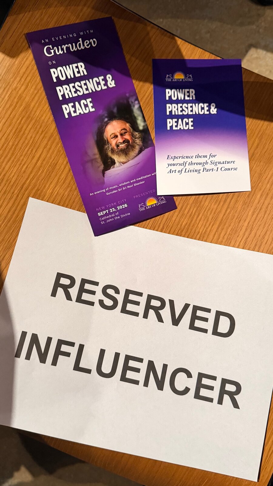 A Reserved Influencer sign beside Art of Living Power, Presence and Peace event flyers