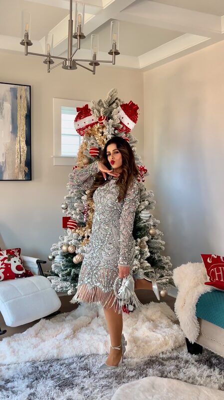 Roopsi Bansal in the Roxie Silver Embellished Shift Dress from Frock and Frill beside a Christmas tree
