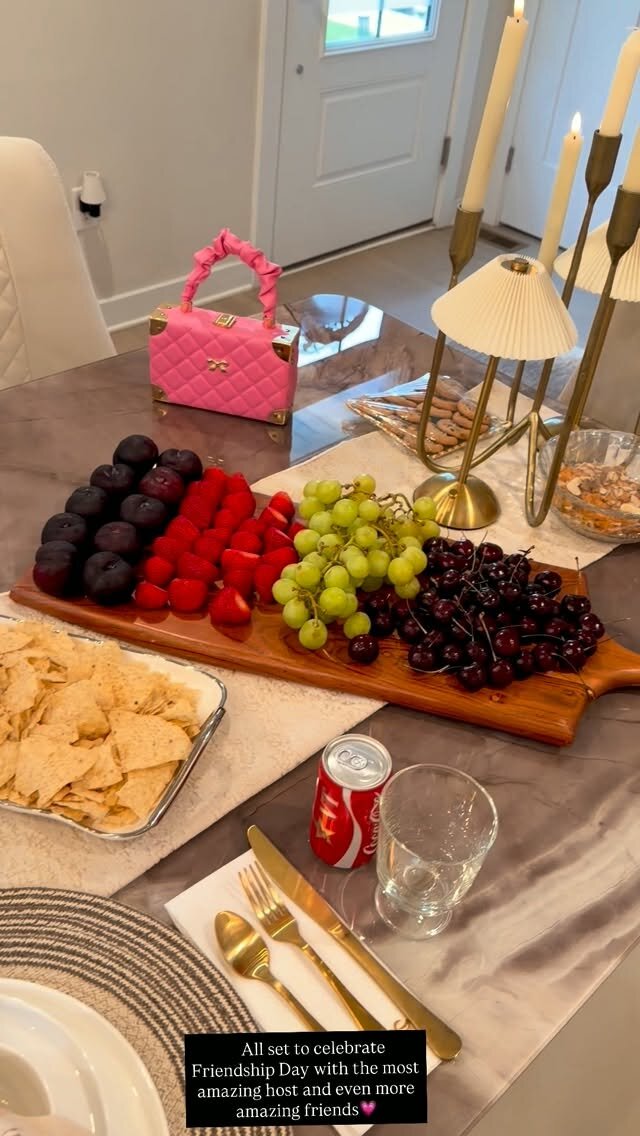 A fruit board with strawberries, grapes, cherries, and plums, plus chips and a Coke, set out to celebrate Friendship Day