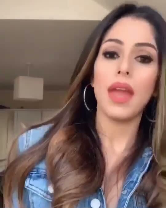 Roopsi Bansal in a denim jacket and hoop earrings, filming a fill-in-the-blank video about Spanish sayings