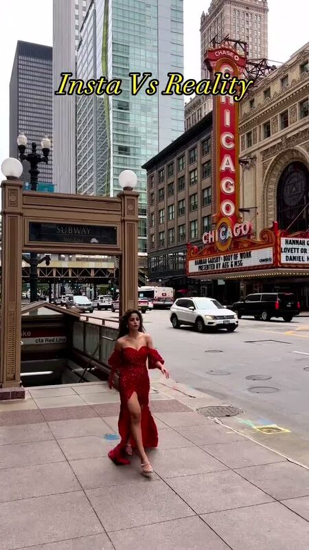 Roopsi Bansal in a red sequin off-shoulder gown standing in front of the Chicago Theatre marquee
