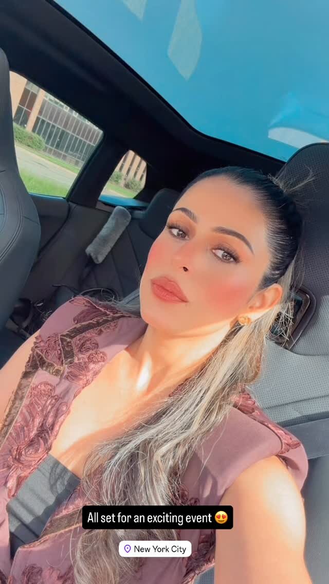 Roopsi Bansal in a mauve textured top taking a car selfie on the way to the event