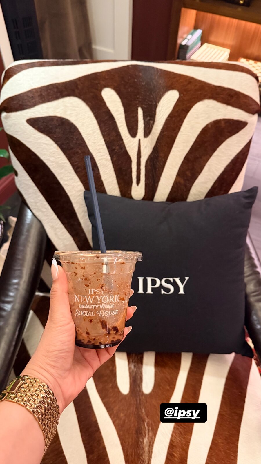 An iced coffee from IPSY New York Beauty Week Social House held up against a zebra-print chair