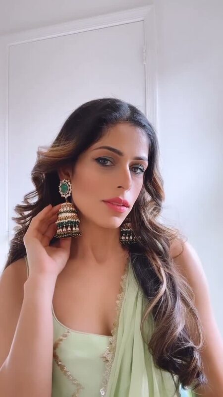 Roopsi Bansal in a sage green saree showing off ornate gold and green jhumka earrings from Jaipur Rose