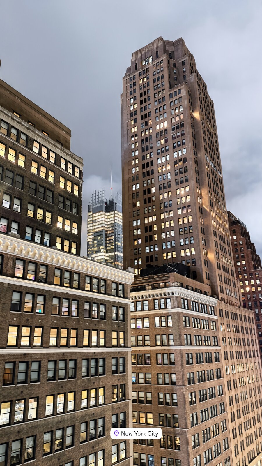 New York City skyscrapers lit up against a gray sky