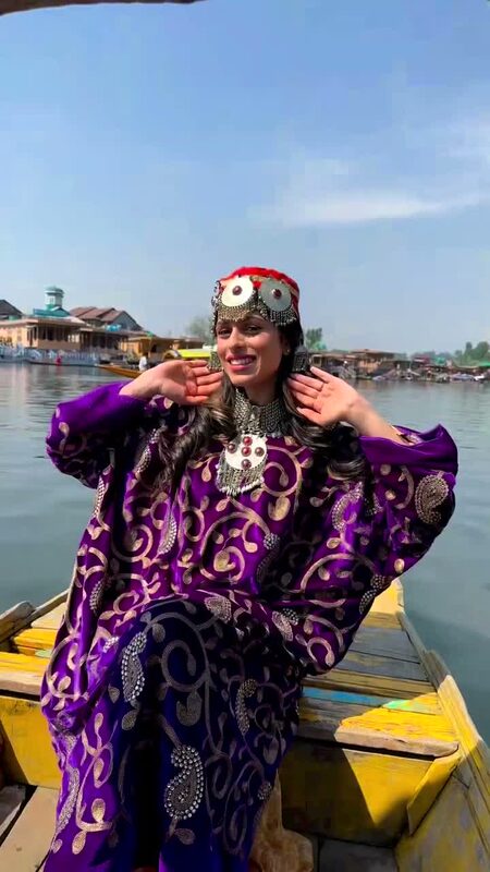 Roopsi Bansal in a traditional purple pheran and silver headpiece sitting on a boat on Dal Lake, Kashmir