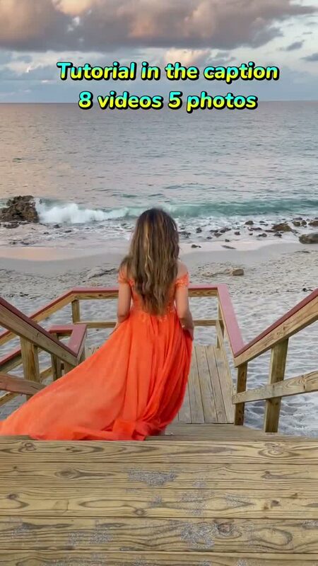 Roopsi Bansal from behind in a flowing orange gown, descending a wooden staircase toward the ocean at dusk