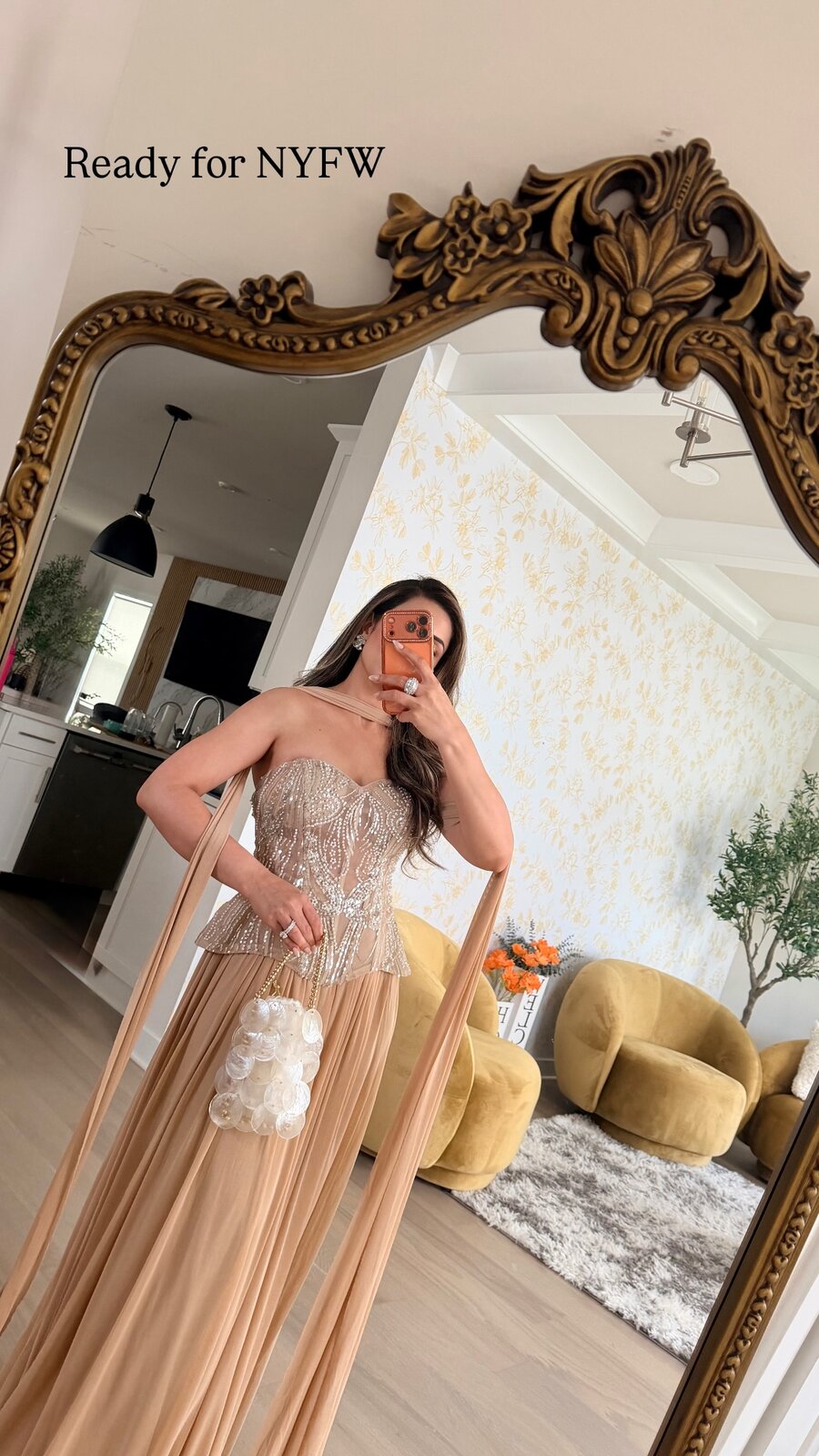 Roopsi Bansal in a champagne beaded gown with sheer draped sleeves, taking a mirror selfie captioned Ready for NYFW