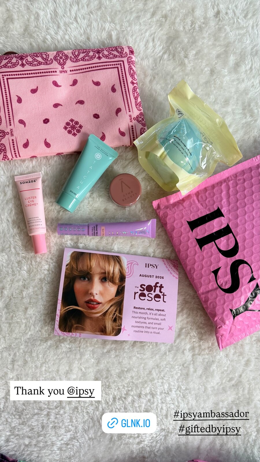 An IPSY August 2026 beauty box unboxing with a pink bandana pouch, Tatcha cleanser, and other beauty minis