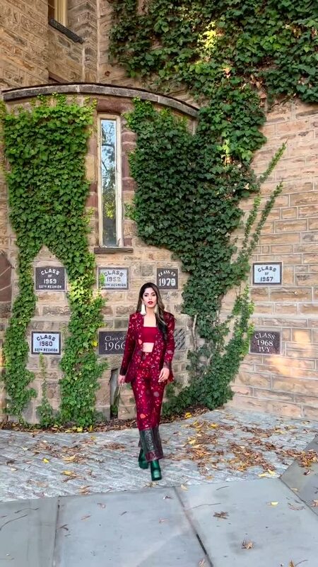 Roopsi Bansal in the maroon printed Mihrab blazer-and-pant set, standing at the same ivy-covered Princeton wall as her earlier post