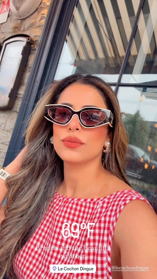 Roopsi Bansal in sunglasses and a red gingham top on a restaurant patio at Le Cochon Dingue, with a text overlay reading 69 degrees, brunch and the beautiful weather