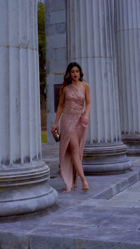 Roopsi Bansal in a one-shoulder rose-gold sequin gown walking between grand marble columns at Princeton, New Jersey