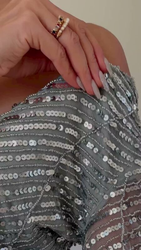 Close-up of Roopsi Bansal's hands resting on the sage sequin embroidery of a long-sleeve maxi dress
