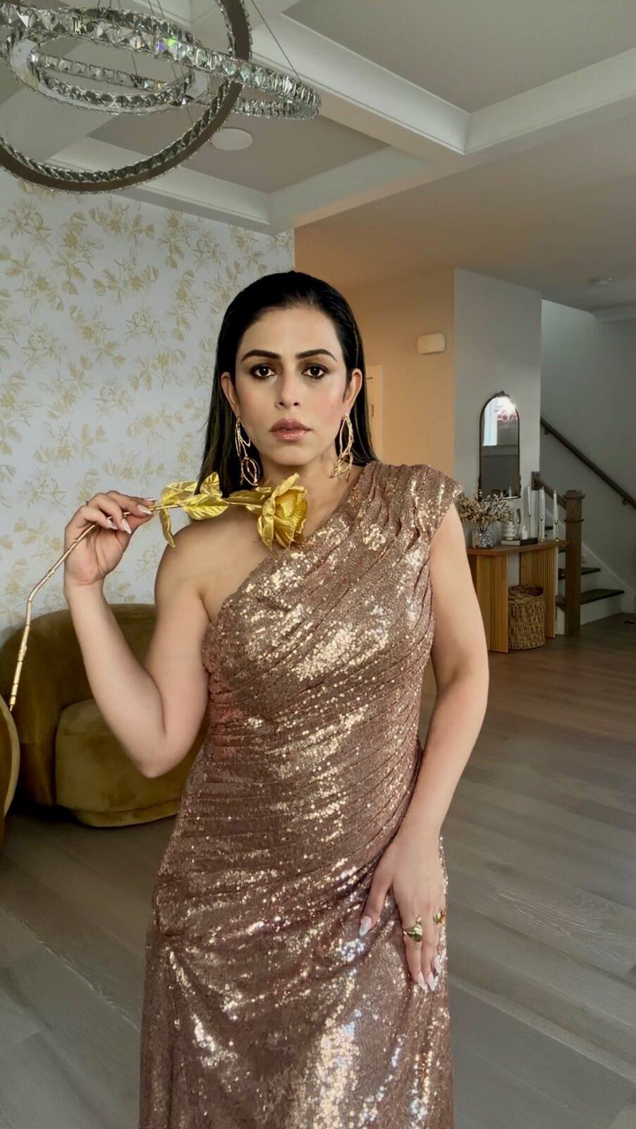 Roopsi Bansal in a gold one-shoulder sequin evening dress