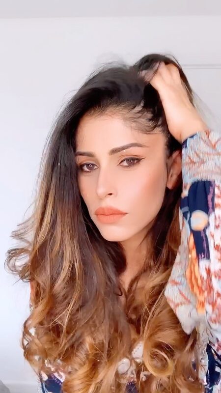Close-up of Roopsi Bansal with tousled waves, wearing a multi-print wrap dress sleeve