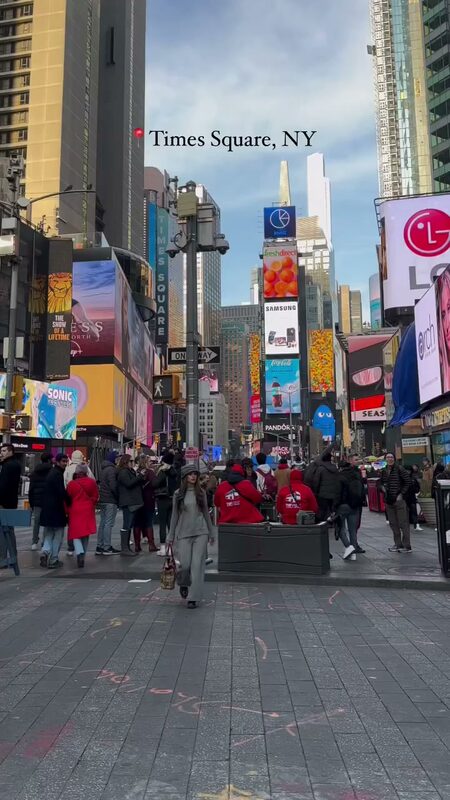 Roopsi Bansal in a grey high neck knit set from Chicwish walking through Times Square