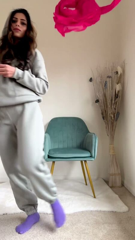 Roopsi Bansal in gray loungewear at home next to a teal velvet dining chair, mid-transition-reel