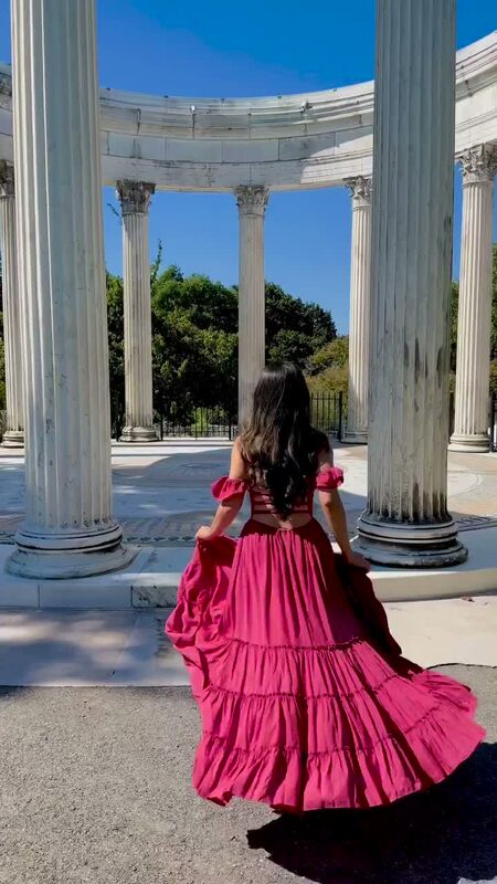 Roopsi Bansal in a pink tiered maxi dress from Coco Pina beneath the colonnade at Untermyer Park and Gardens in Yonkers, New York